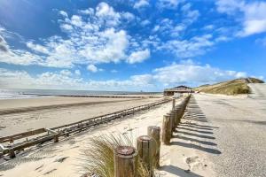 a beach with a wooden fence and the ocean at De Zilten Kaēmer Zoutelande in Zoutelande