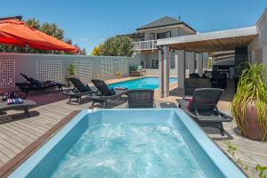 a swimming pool with chairs and a hot tub at Villa Venusta Luxury Guesthouse - Solar Power in Hermanus