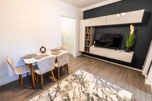 - un salon avec une table, des chaises et une télévision dans l'établissement New Home Studio, à Zalău