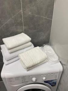 a pile of towels sitting on top of a washing machine at 2-х комнатные апартаменты in Taldykolʼ