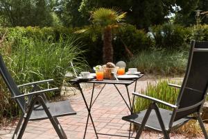 a table with a basket of food and two chairs at Spa Hotel Amsee in Waren