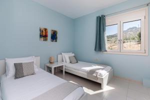 um quarto com 2 camas e uma janela em Villa Marcella em Plakiás