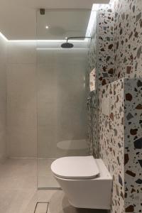 uma casa de banho com um WC branco e um chuveiro em Villa Marcella em Plakiás