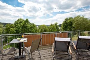 einen Balkon mit Stühlen und einem Tisch auf einer Terrasse in der Unterkunft Spa Hotel Amsee in Waren (Müritz)