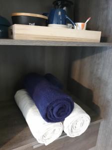 un estante con toallas y una toalla azul en La SPACIEUSE- Chambre privée-Cosy-Climatisée, en Genilac