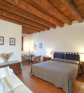 1 dormitorio con 1 cama, mesa y sillas en Agriturismo Tenuta La Pila, en Villa Bartolomea