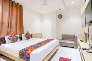 FabHotel Harriot في بوبال: غرفة نوم بسرير كبير وأريكة