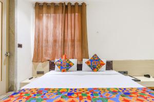 FabHotel Harriot في بوبال: غرفة نوم مع سرير مع لحاف ملون