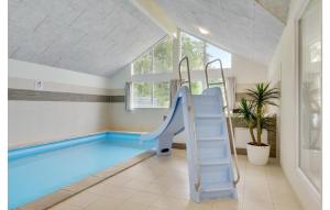 una piscina cubierta con un tobogán en una habitación en Amazing Home In Frederiksvrk With 8 Bedrooms, Wifi And Indoor Swimming Pool, en Frederiksværk