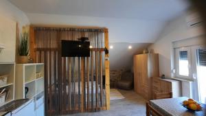 a living room with a sliding glass door with a television at Apartmani Goga in Skradin +52 photos