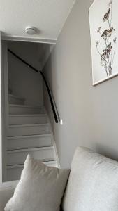 Cette chambre dispose d'un escalier avec un canapé et un escalier. dans l'établissement ' Zilten Huus Zoutelande, à Zoutelande