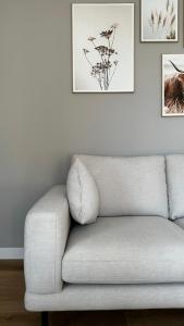- un canapé dans le salon avec des photos sur le mur dans l'établissement ' Zilten Huus Zoutelande, à Zoutelande