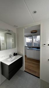 a white bathroom with a sink and a mirror at ' Zilten Huus Zoutelande in Zoutelande