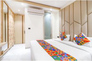FabHotel Harriot في بوبال: غرفة نوم مع سرير مع بطانية ملونة عليه