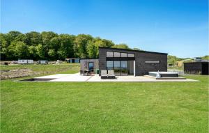 een klein zwart huis op een grasveld bij Amazing Home In Sjlund With Kitchen in Sjølund