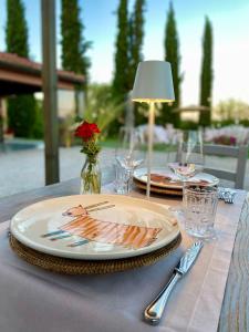 奇塔德拉皮耶韋的住宿－Poggiovalle Tenuta Italiana，一张桌子,上面有两盘,上面有台灯