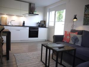 a living room with a couch and a table and a kitchen at Ocean Hill in Scharbeutz