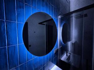 a bathroom with a blue lighted mirror on the wall at Comfort Hostel Klaipeda in Klaipėda