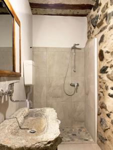 La salle de bains est pourvue d'une douche et d'un lavabo en pierre. dans l'établissement Antica Torre, à Sondrio