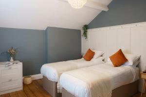two beds in a room with blue and white walls at Loft Fawr in Tregaron