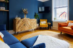 a living room with blue walls and a blue couch at Loft Fawr in Tregaron