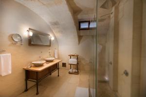 a bathroom with two sinks and a glass shower at Anatolian Houses Cave Hotel & SPA in Göreme