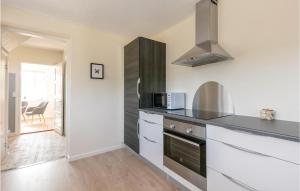 a kitchen with a stove and a microwave at Two-Bedroom Holiday Home In Gudhjem in Gudhjem