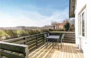 a wooden deck with a table and chairs on it at Beautiful Home In Gudhjem With 2 Bedrooms And Wifi in Gudhjem