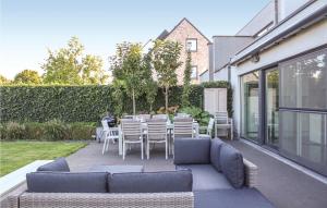 een patio met een bank en een tafel en stoelen bij 4 Bedroom Awesome Home In Brugge in Brugge