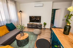 ein Wohnzimmer mit einem Sofa und einem Tisch in der Unterkunft Stylish Oasis Central Apartment with AC and Parking in Budapest