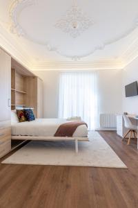 a bedroom with a bed and a white ceiling at Evora Spot Rooms in Évora