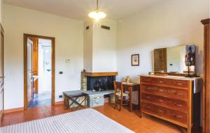 a bedroom with a bed and a dresser and a fireplace at La Quiete in Moggiona