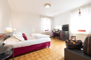 een hotelkamer met een bed en een bureau bij Hotel Pittini in Gemona del Friuli