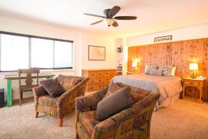 1 dormitorio con 1 cama y 2 sillas en Explorer's Retreat, en Taos