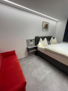 ヴァークラインにあるFerienhaus Zentralのベッドルーム1室(ベッド1台、赤いソファ付)