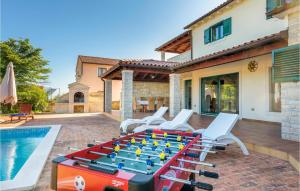 a ping pong table on a patio next to a pool at Nice Home In Valtura With Kitchen in Valtura