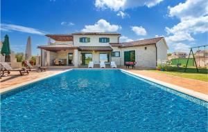 a villa with a swimming pool in front of a house at Nice Home In Valtura With Kitchen in Valtura