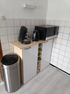 a small kitchen with a microwave and a trash can at Feriënhaus Hohe Acht in Siebenbach
