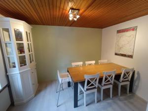 a dining room with a wooden table and chairs at Feriënhaus Hohe Acht in Siebenbach