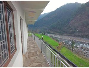 een balkon met uitzicht op een rivier en de bergen bij Hotel Tapovan Ganga view, Uttarkashi in Uttarkāshi
