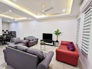 a living room with two couches and a television at Botani Tmn Cyber Ipoh(24 pax /tv box/mahjong) in Ipoh