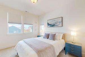 a white bedroom with a bed and two windows at Butler Creek Retreat in Belgrade