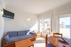 a living room with a couch and a table at Edifício Sequeira - Alojamento Local by Umbral in Albufeira