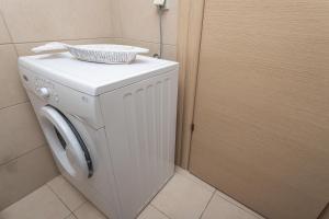 シビリにあるPure White Suite Elaniの洗濯機(バスケット付)
