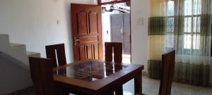 韦利格默Sriya Family Villa Weligama的一间带桌子和木门的用餐室