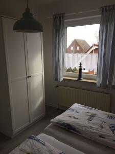 um quarto com uma cama e uma janela em Ferienwohnung "Kleine Krabbe" em Werdum