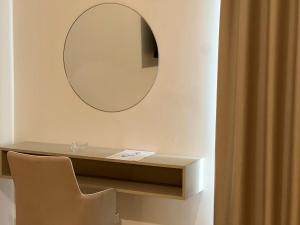 a mirror on a wall with a table and a chair at Hotel Futuro in Aversa