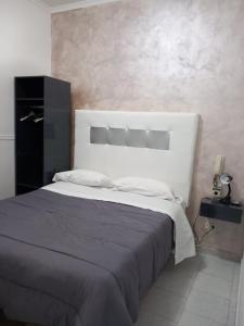 um quarto com uma cama grande e uma grande cabeceira. em Hotel stranamore em Varcaturo