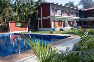 a resort with a swimming pool in front of a building at Sk Resort in Alibaug
