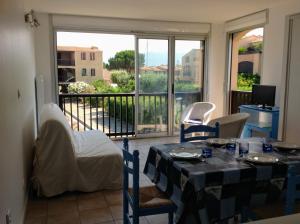 een eetkamer met een tafel en een balkon bij Appartement-Marina climatisé 4 couchages avec Piscine in Saint Cyprien Plage